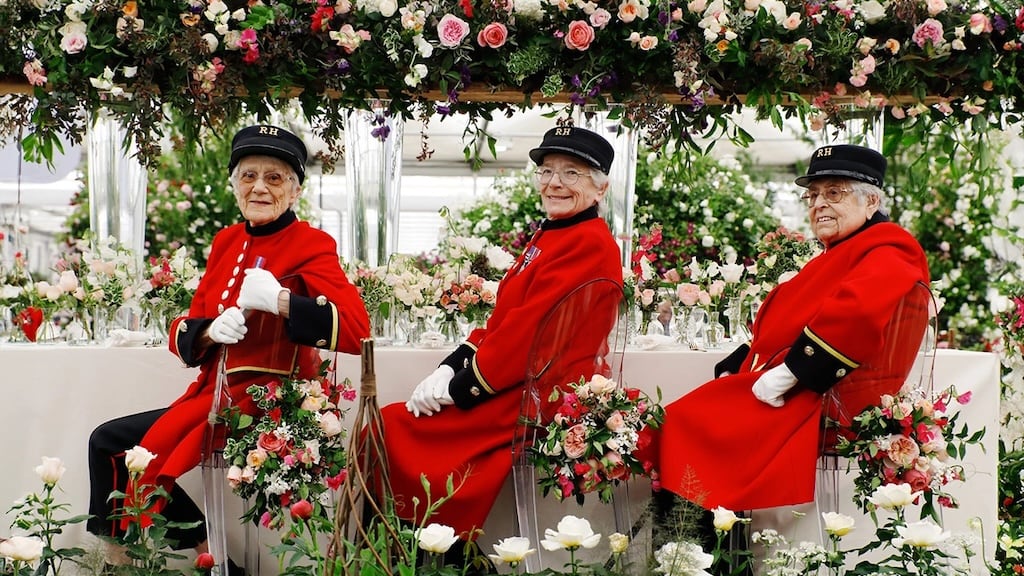 Chelsea Pensioners in scarlet coats welcoming visitors at the show